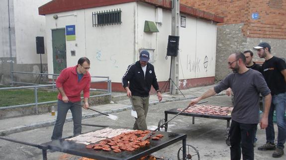 Integrantes de la Asociación Cultural La Tahona preparando los productos del cerdo al fuego. C. Catalina