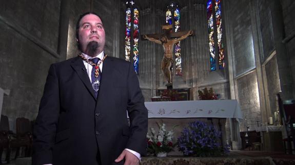 Alfonso Guerra, hermano mayor de la Real y Venerable Cofradía de la Preciosísima Sangre de Nuestro Señor Jesucristo, con la imagen de Genaro Lázaro Gumiel detrás.