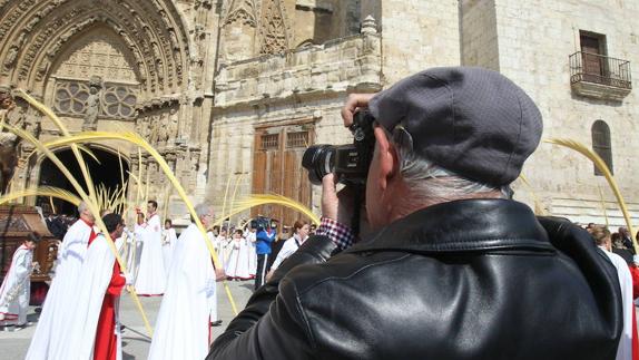 Un turista toma fotos de la procesión de Domingo de Ramos en Palencia. 