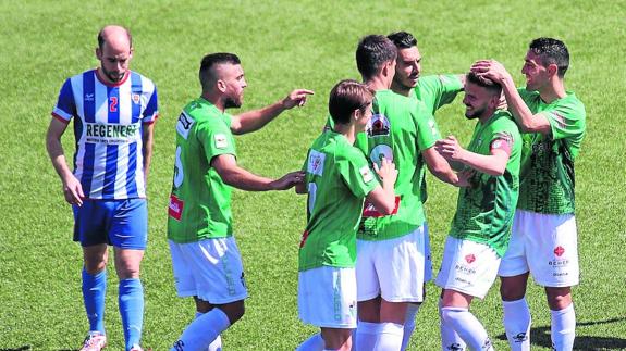 Los jugadores del CDGuijuelo celebran uno de sus goles ante el Izarra ante un rival cabizbajo del conjunto navarro. 