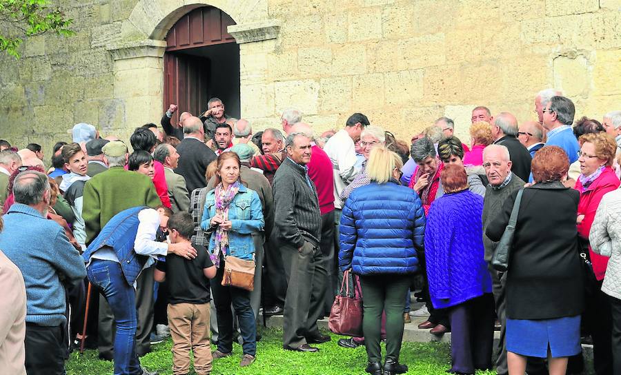Cientos de fieles aguardan la cola para el reparto del pan y queso en Torquemada.