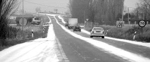 Varios vehículos circulan por la carretera de Villalpando, en el tramo de acceso a la autovía, con nieve en la calzada. / LUIS CALLEJA