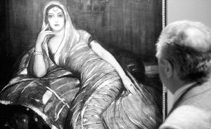 Una mujer contempla el cuadro de temática segoviana 'Procesión de Viernes Santo en Turégano. / ANTONIO DE TORRE