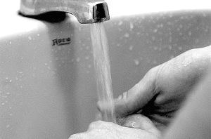 Una persona se lava las manos bajo el chorro del grifo de un lavabo. / A. DE TORRE