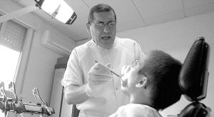 Un dentista examina la boca de un niño en una clínica dental. / EL NORTE