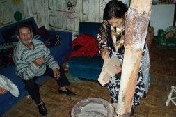 Antonio explica su situación mientras su mujer, Adoración, echa leña a la estufa en la chabola principal de Juana Jugan. / J. S.