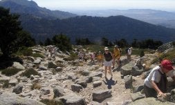 Un grupo de excursionistas durante una de las rutas que discurren a mayor altitud, con el valle de Valsaín al fondo. / EL NORTE