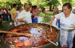 Gente hace cola en la Alameda del Parral mientras el cocinero, Julián del Barrio prepara las raciones de los asistentes. /ANTONIO TANARRO