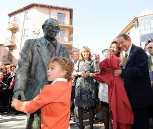 Un nieto de Ramos toca la estatua ante la sonrisa del abuelo, la alcaldesa y la subdelegada./ N. H.