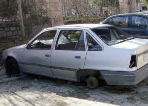 Vehículo deteriorado, sin placas ni ruedas, en el aparcamiento del antiguo Regimiento. ::                             A. DE TORRE