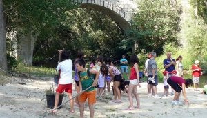 Los niños en un momento de la limpieza del río. ::
EL NORTE