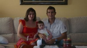 Alfonso Retuerto y su mujer, Ainara, sostienen en sus brazos a su hijo Aimar en el salón de su casa. ::
LEONOR RAMOS
