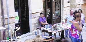Un grupo de personas observan los artículos del puesto situado en el exterior de la tienda en la calle Balborraz. ::
R. CASADO