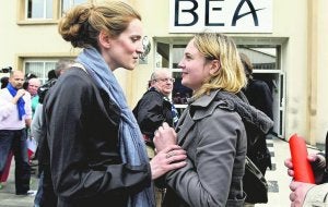 La ministra francesa de Transportes conforta a una joven que perdió a su novio en el vuelo siniestrado. A la derecha, parte del tren de aterrizaje del aparato de Air France. ::
REUTERS/ AP