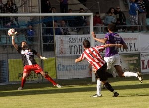 El portero Juan Carlos Castilla repele un disparo del jugador riojano Osado, en presencia del defensa central Rui . ::                             MERCHE DE LA FUENTE