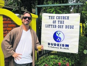 El fundador del 'Dudeism', O. Benjamin, en la Iglesia del Último Nota y un cuadro de un seguidor. ::
EFE