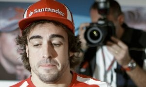 Alonso, durante el protocolo de firma de autógrafos a su llegada al circuito de Yas Marina. :: KARMAN JEBREILE-AP