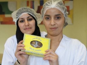 Munia y Sanai muestran una caja con los dulces que elaboran. ::                             HENAR SASTRE
