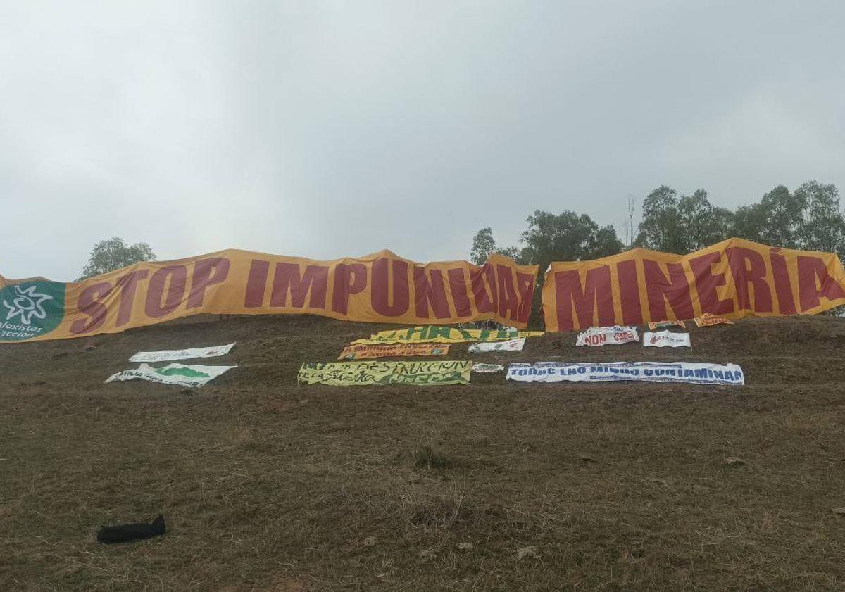 Imagen principal - Arriba, pancartas desplegadas en el cerro de Las Herrerías. Abajo, momentos de la ruta de los participantes de las distintas plataformas antimina.