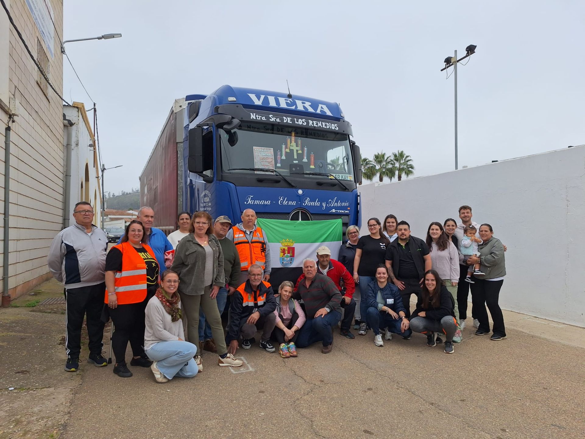 Imagen principal - Arriba, grupo de voluntarios/as de Alconchel que se encargaron de llenar el tráiler. Abajo, recepción del camión en Paiporta, por parte de alconcheleros residentes en la zona, y que agradecen la ayuda recibida de Alconchel y otros municipios pacenses.