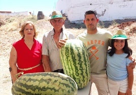 Parte de la familia Merchán posa con dos de las sandías ganadoras