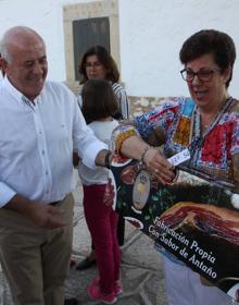 Imagen secundaria 2 - Numerosos fieles acudieron a la cita. En la tercera foto, Juan Antonio Cruz, Mayordomo de la Cofradía, hace entrega del jamón a la agraciada. 