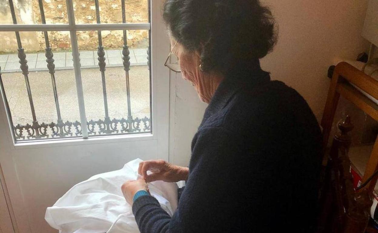 Ángela Boyero, a sus 84 años, cosiendo una bata