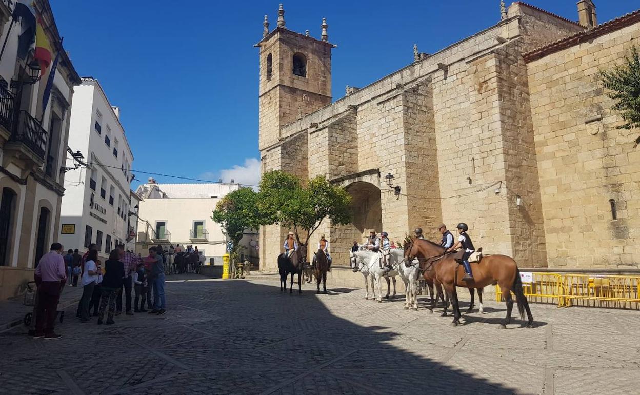 Varias personas miran un grupo de caballos en la Plaza de la Constitución. 
