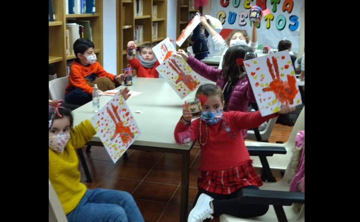 Varios nños con sus pinturas durante la Hora del Cuento. 