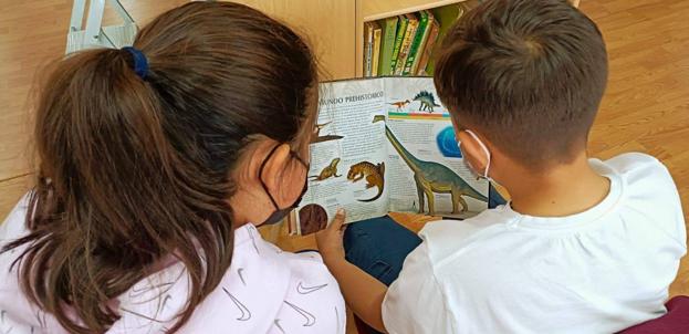 Imagen principal - Dos pequeños tras la vacunación en la biblioteca escolar. 