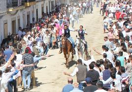 Un jinete y una amazona bajan al galope por la Corredera. Día de la Luz 2022.