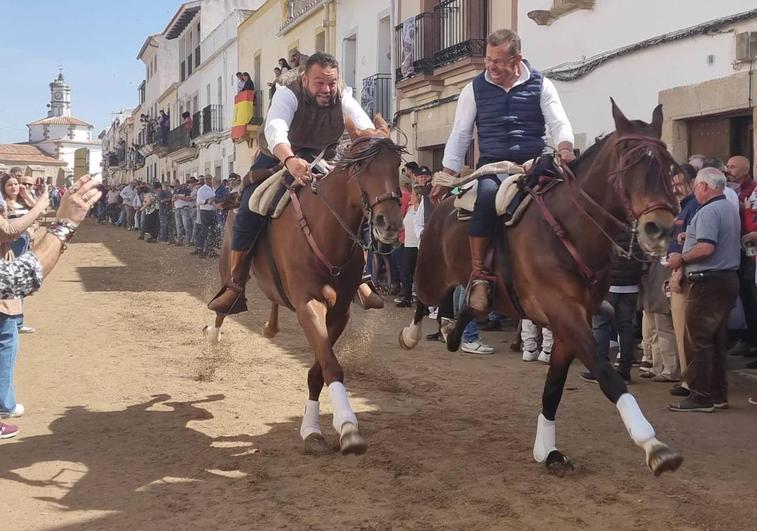 Dos caballistas bajando a galope la Corredera.