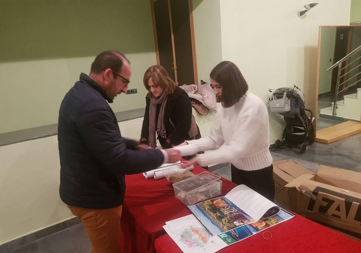 Imagen principal - Reparto de los caldendarios solidarios en la entrada.