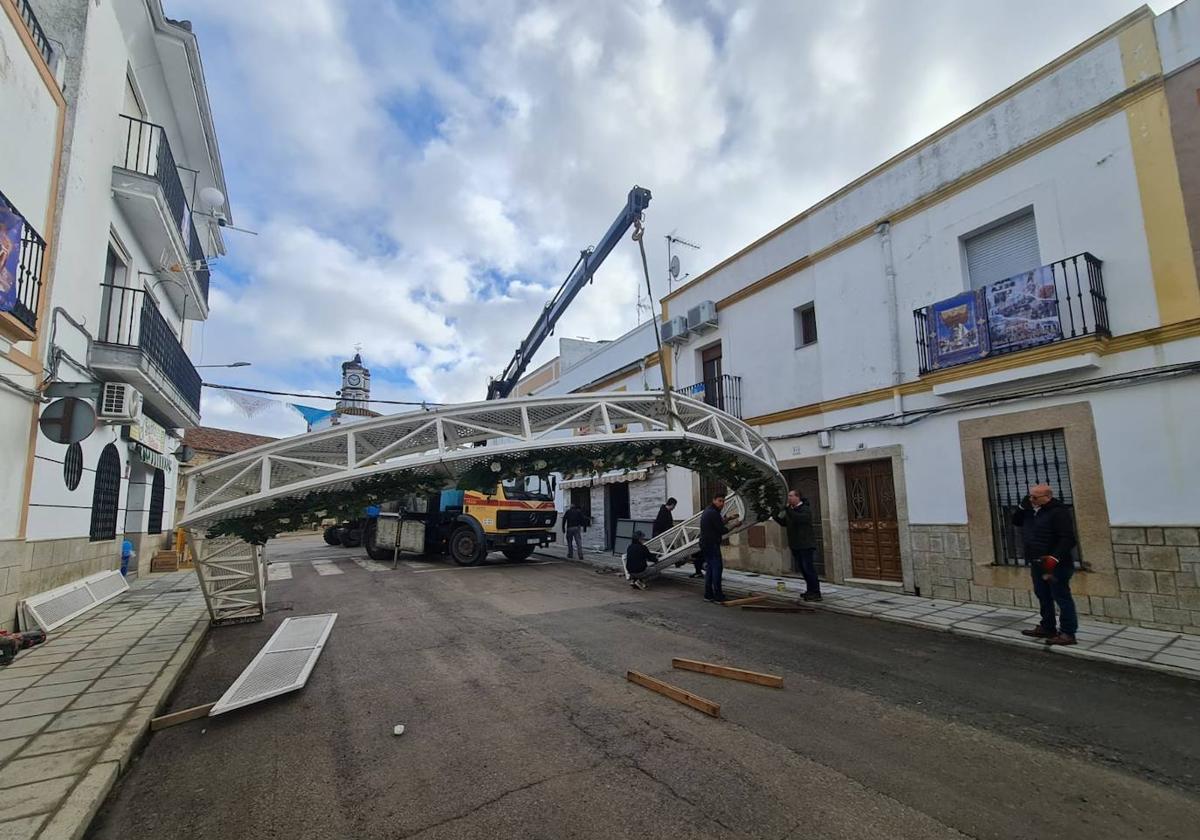 Los operarios levantan el arco de flores.