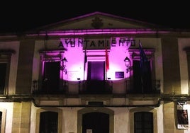 La fachada del Ayuntamiento iluminada de morado.