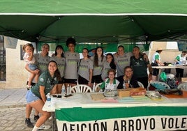 Jugadoras del Extremadura Arroyo posan delante del stand de la peña.