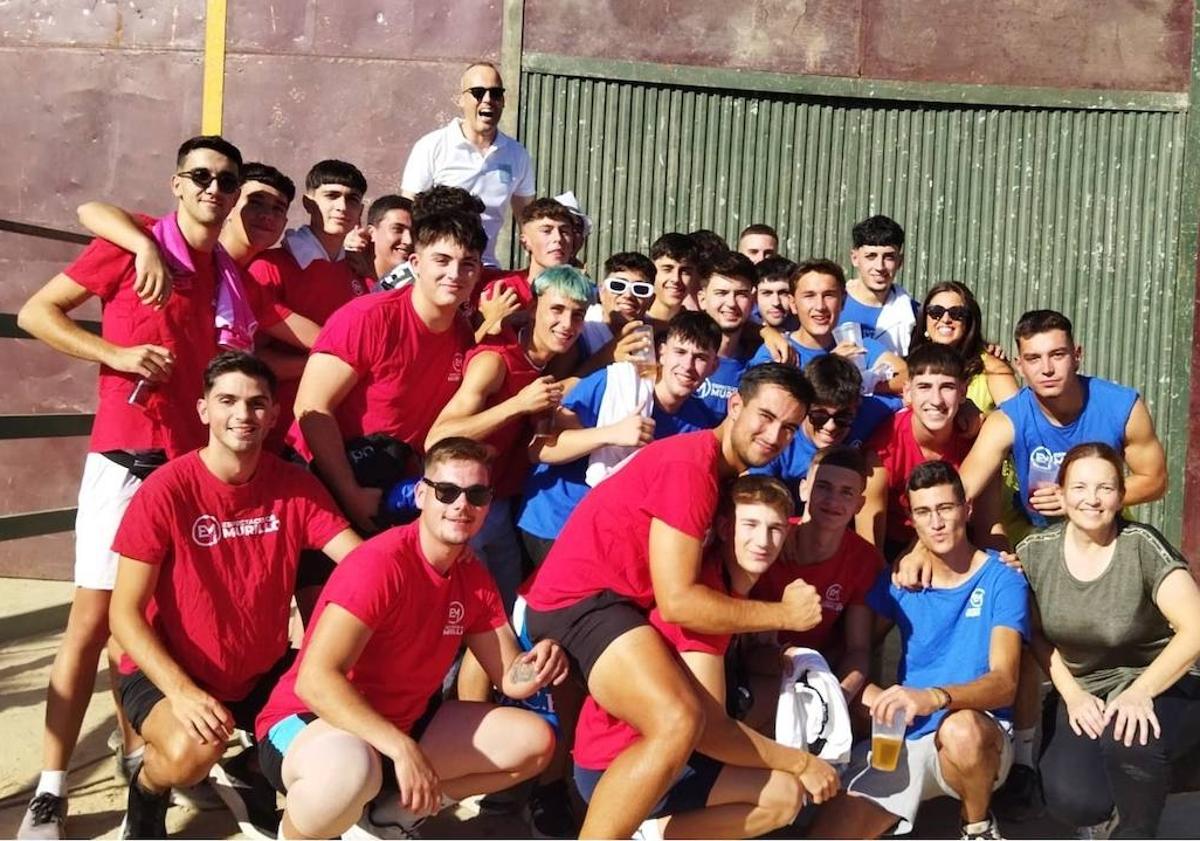 Imagen principal - Foto de familia del equipo rojo y el equipo azul junto a Carlos Caro, alcalde de la localidad, y Mariluz Castaño, concejala del Ayuntamiento.