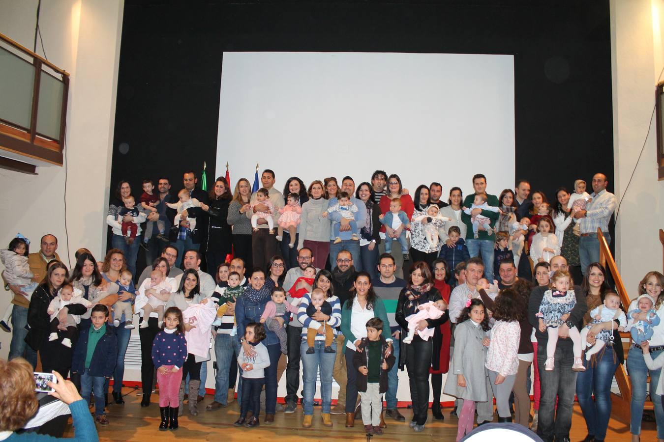 Foto de familia de los bebés, sus familias y las autoridades. 