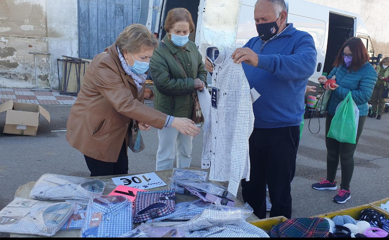 Unas clientas se interesantes por unas camisas. 