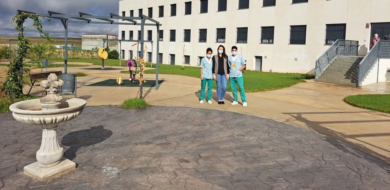 La directora de la residencia 'Las Colmenillas', Belén Sánchez, junto a dos trabajadores en el jardín del centro 