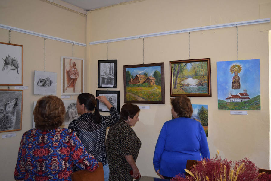 Vecinos visitando la exposición de pinturas. 