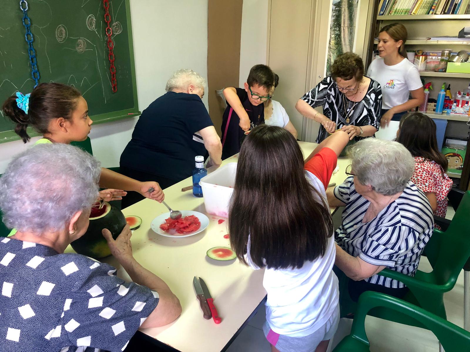 Mayores y niños vacían la sandía para hacer los farolillos. M.C.