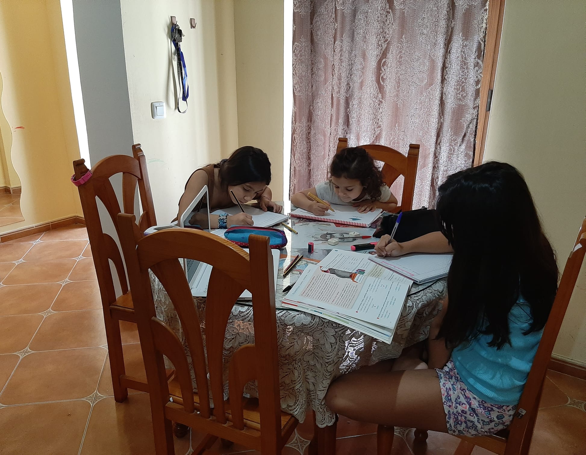 Las hermanas comparten mesa para hacer las tareas cada día. 