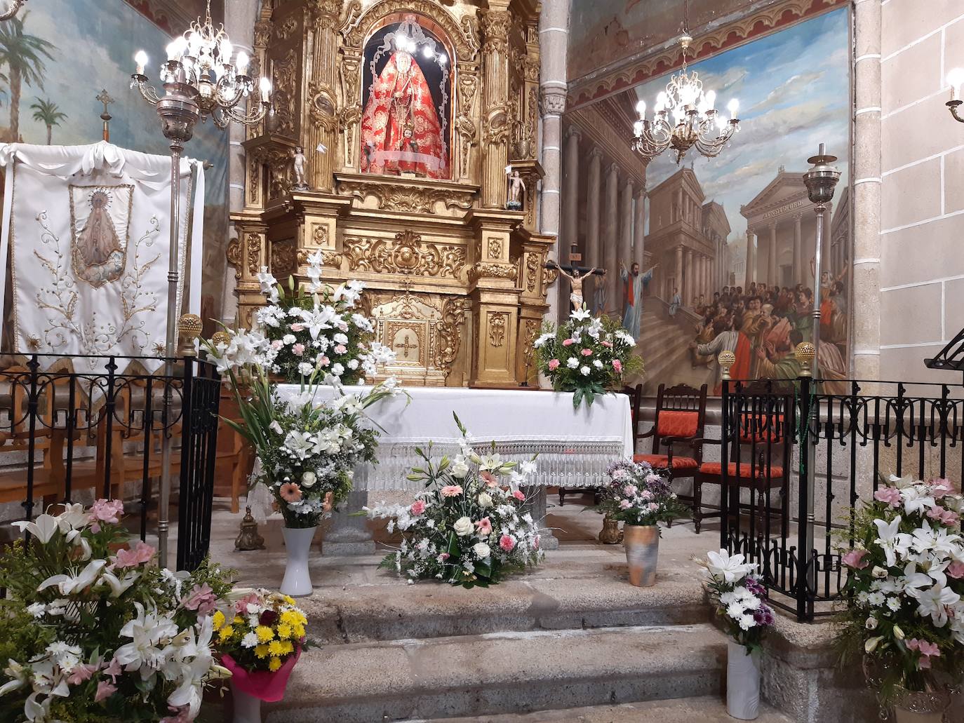 Numerosos centros florales decoraban el altar de la ermita. 
