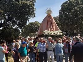 Los devotos se han turnado para llevar a la Virgen durante la breve procesión por las proximidades de su santuario.