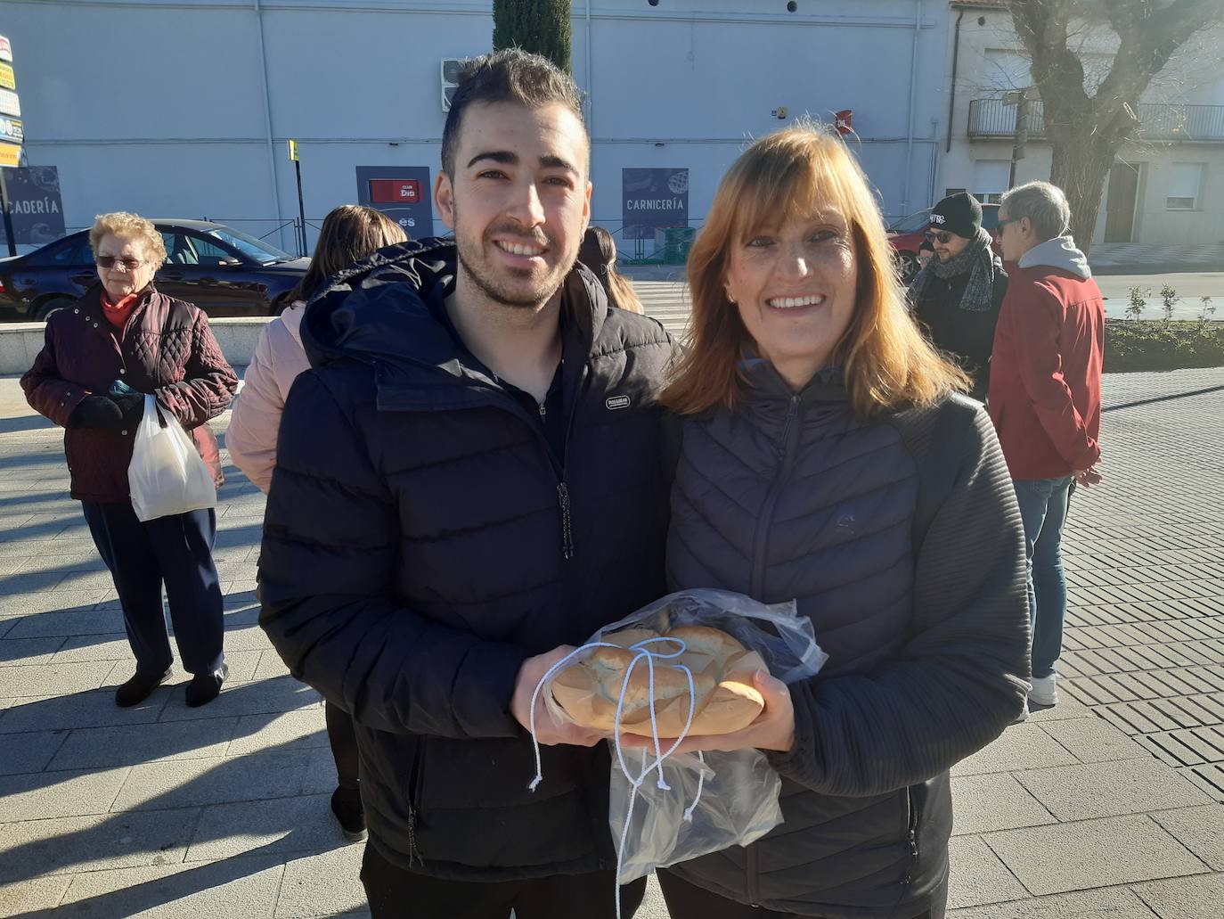 Imagen secundaria 1 - Los casareños han acudido a buscar las roscas. Álvaro Maya junto a su madrina Loli. Se han vendido 2.000 roscas de San Blas. 