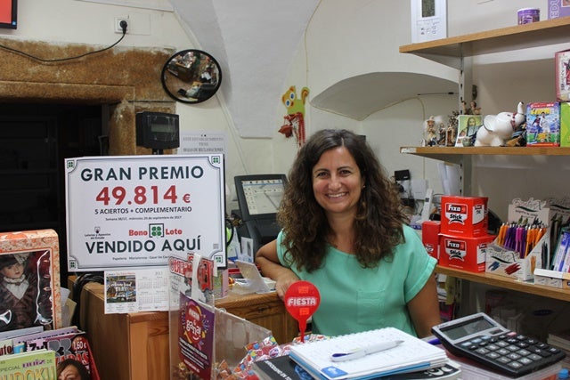 Teresa Pérez hoy junto al cartel del premio vendido en su establecimiento. 