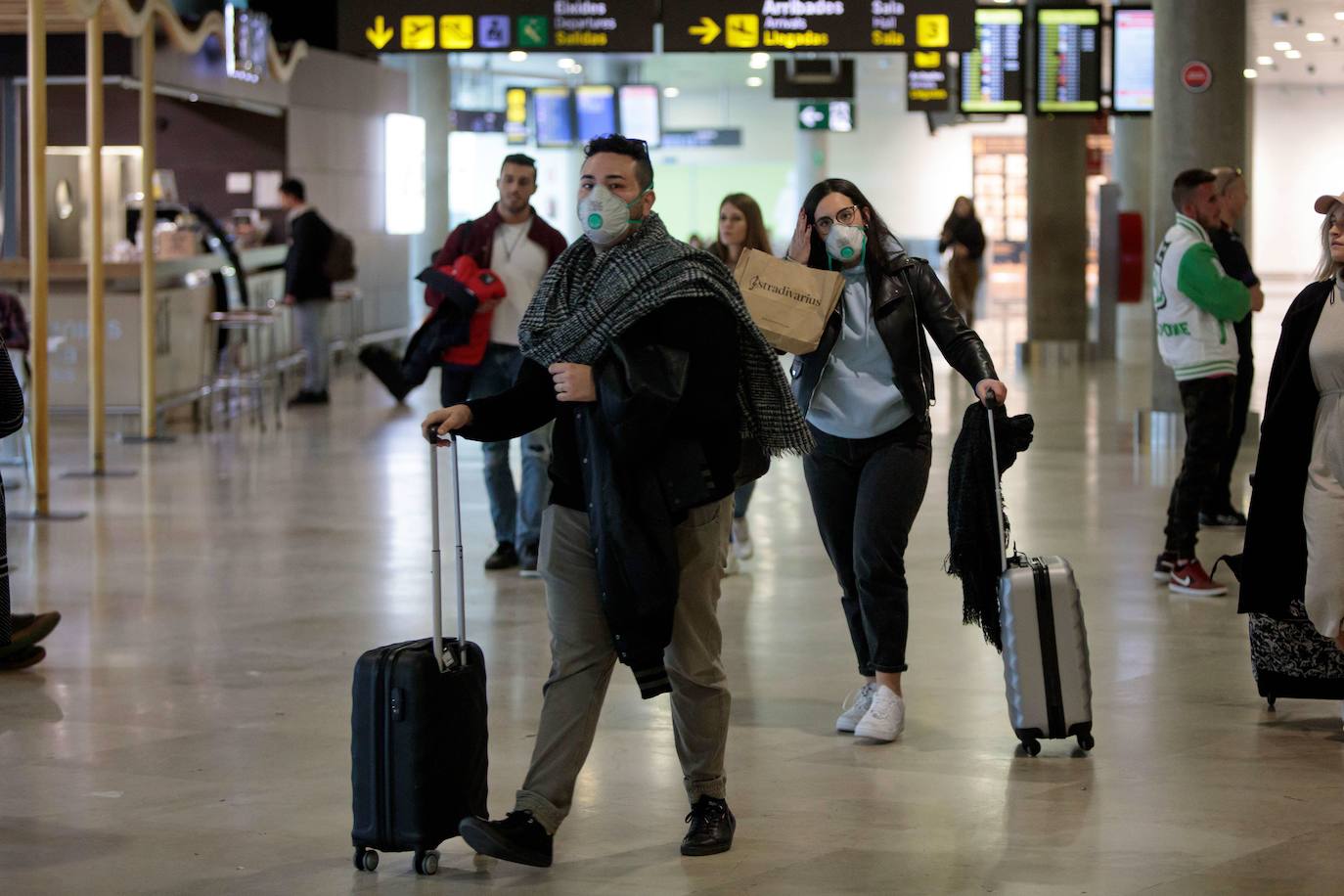 Viajeros procedentes de Italia protegidos con mascarillas a su llegada al aeropuerto de Manises (Valencia)