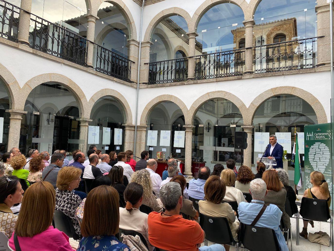 Imagen secundaria 1 - Arriba: En tercera posición por la izquierda, el ganador del permio, junto a las autoridades. Debajo: El alcalde de Coria durante su intervención en el acto. 