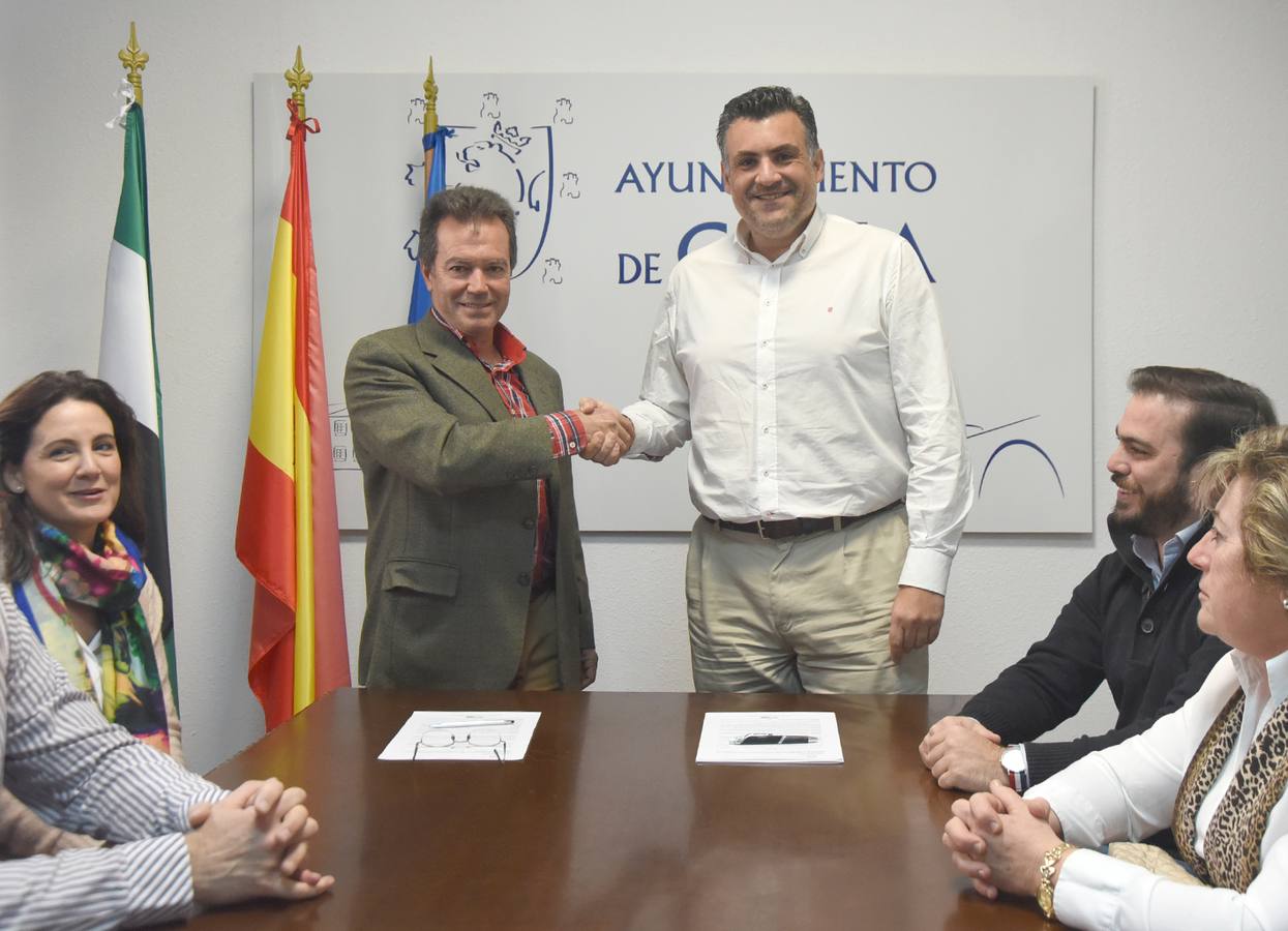 El alcalde y el presidente de la Unión de Cofradías se dan la mano tras la firma del convenio de colaboración